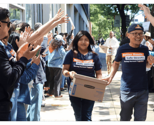 Youth and volunteers walks one of fifteen boxes comprising of the 32,000 signatures collected by Better Roads, Safe Streets to advance the Better Roads, Safe Streets transportation measure