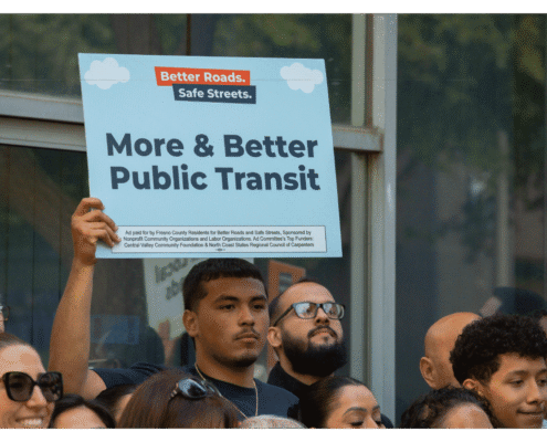 Advocate of Better Roads Safe Streets holds up a sign "More & Better Public Transit" outside of the Fresno County Elections Office during press event announcing the submission of over 32,000 signatures to advance transportation measure toward November ballot
