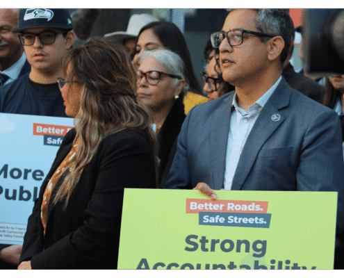 Miguel Arias of Better Roads Safe Streets holds up a sign "Strong Accountability" outside of the Fresno County Elections Office during press event announcing the submission of over 32,000 signatures to advance transportation measure toward November ballot