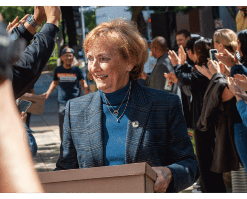Lynne Ashbeck walks one of fifteen boxes comprising of the 32,000 signatures collected by Better Roads, Safe Streets to advance the Better Roads, Safe Streets transportation measure